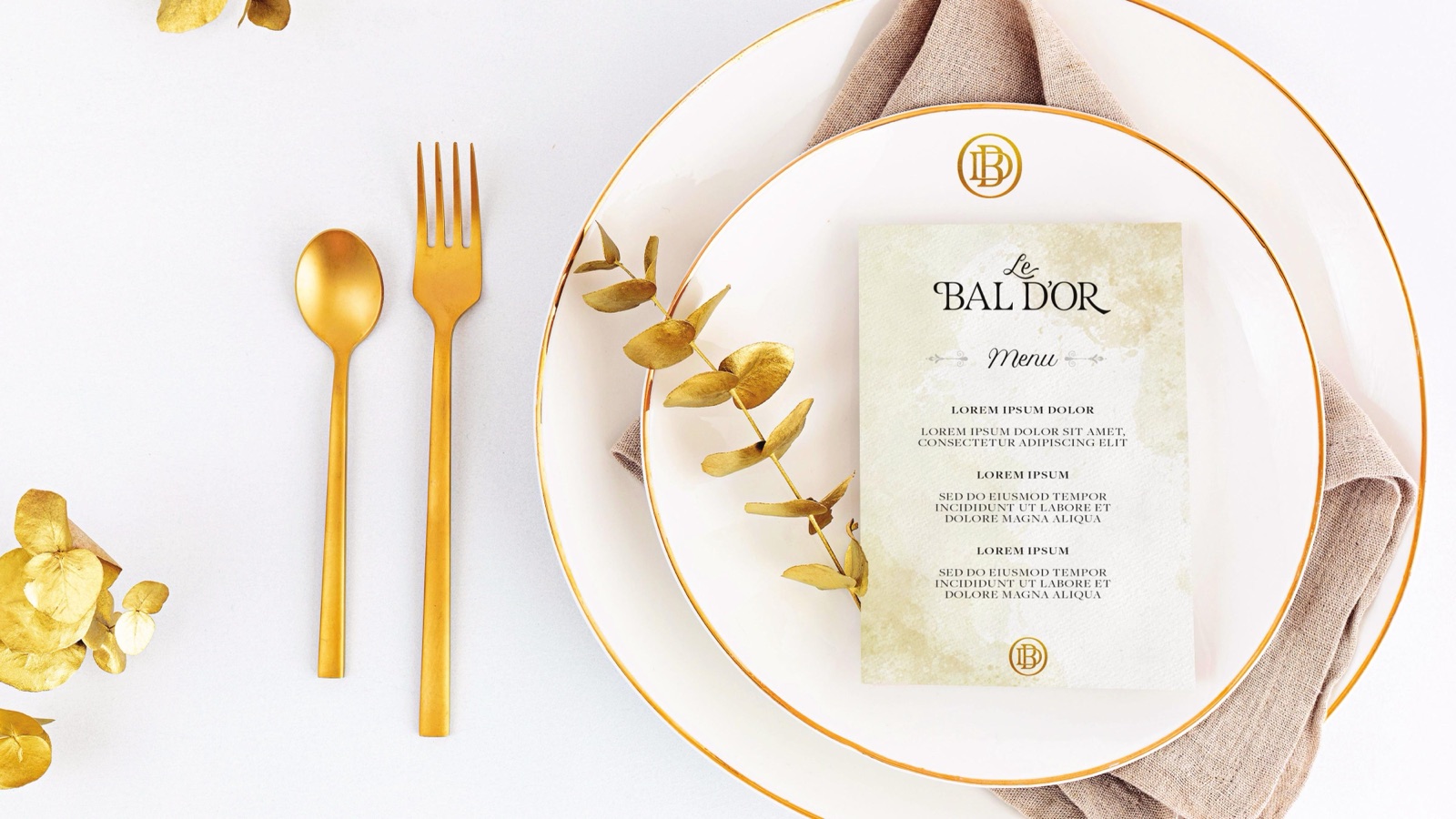 A Le Bal D'Or menu on a plate with gold cutlery